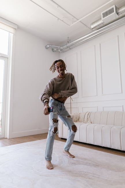 A carefree individual dancing energetically in a bright, modern living room with a cozy sofa.